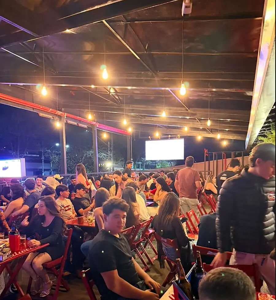 Salão do Josepio lotado à noite, com lâmpadas acesas e telões