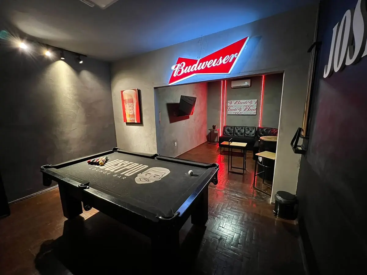 Lounge da Sala VIP com sofás de couro e listras vermelhas na parede